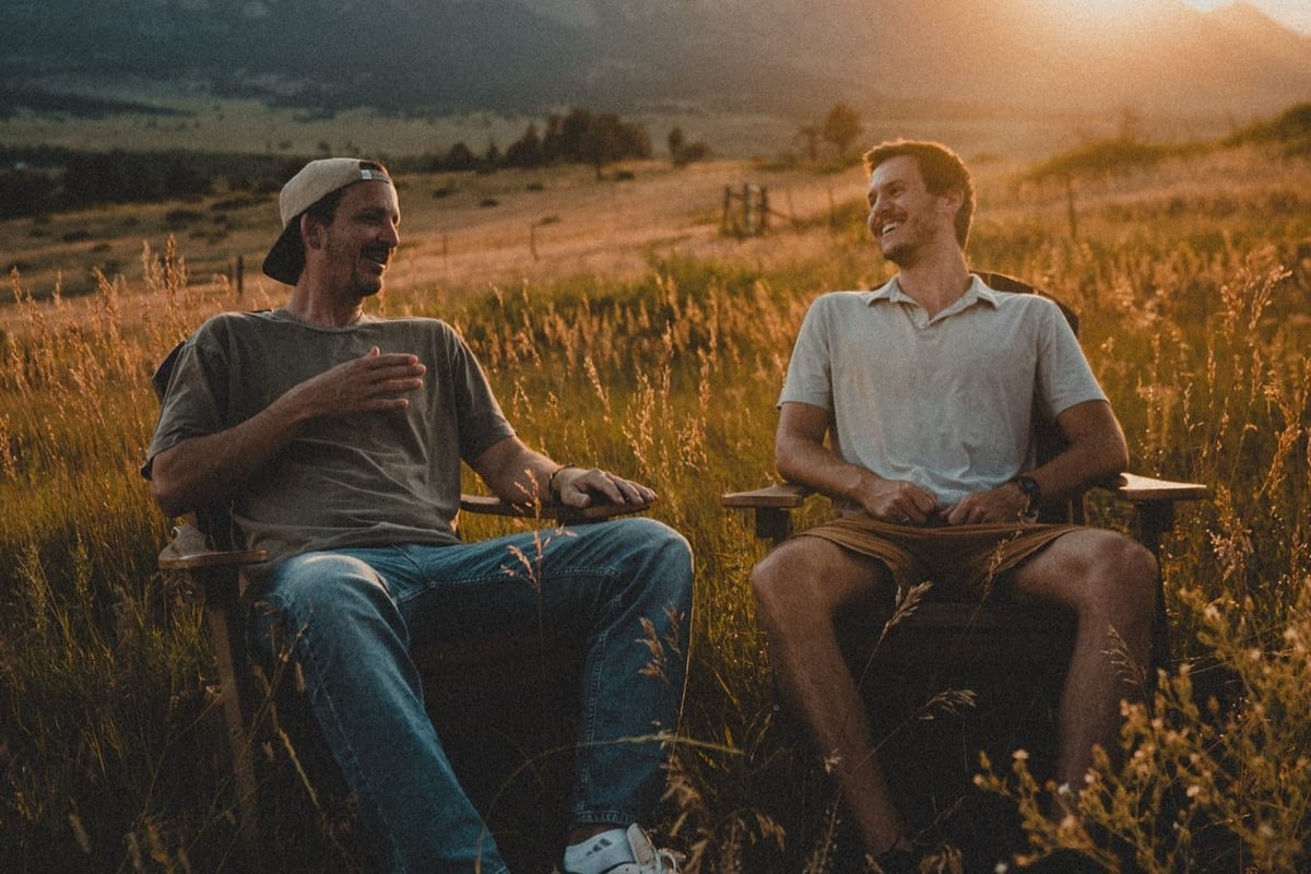 Daniel Norris and Josh Caliguire, Frelio's co-founders, talking in a field at sunset