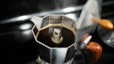 Freshly brewed coffee in the top chamber of an open octagonal stovetop moka pot