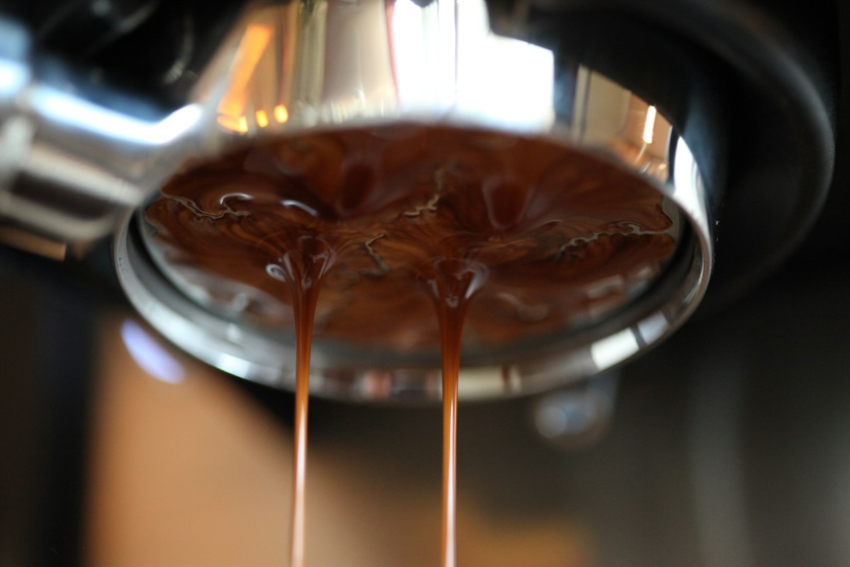 Espresso running in several separate streams from a bottomless portafilter, a sign of channeling