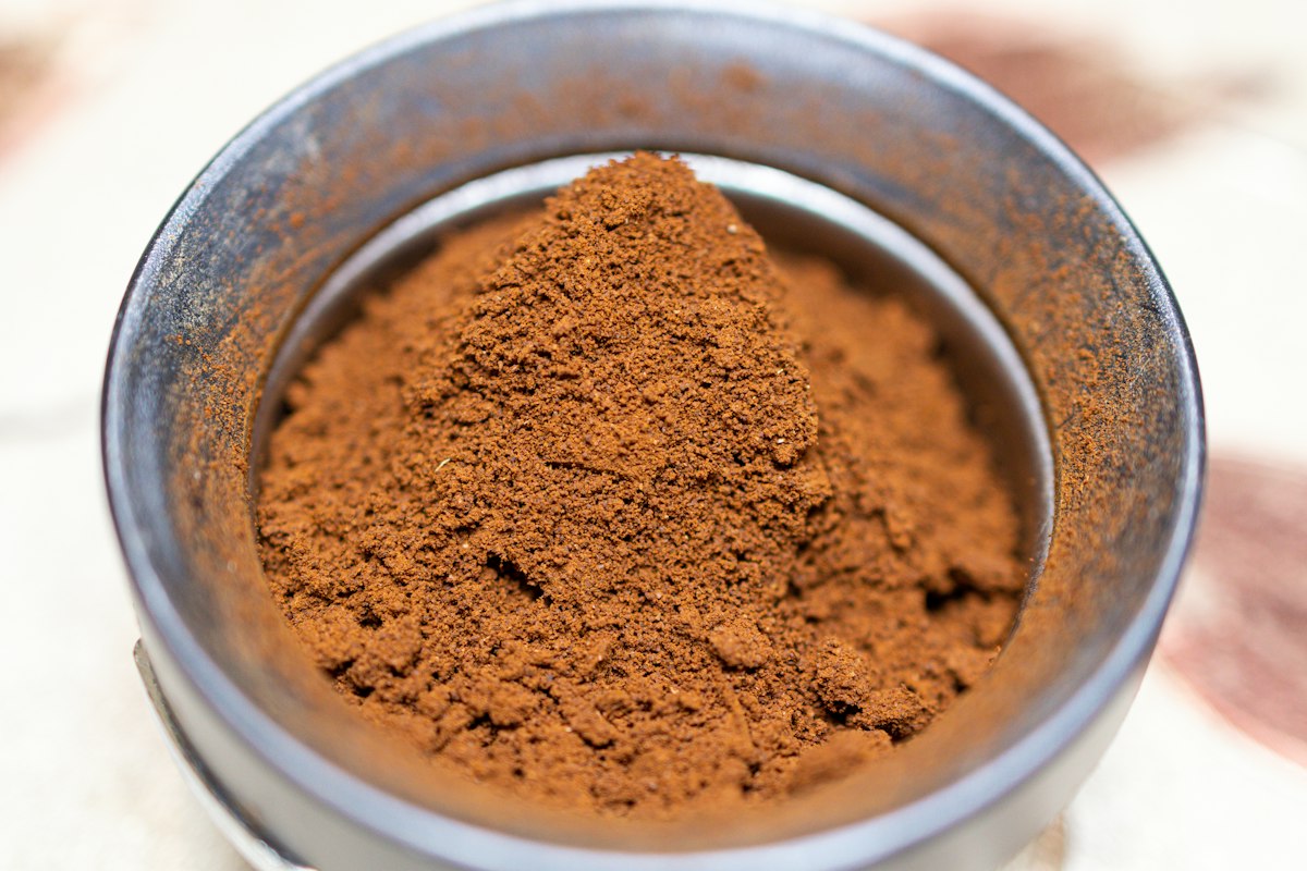Evenly distributed ground coffee sitting in a stainless espresso portafilter basket
