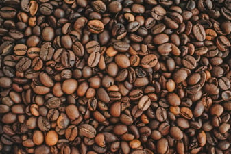 Roasted Arabica coffee beans spread out, showing the range of colors across roast levels