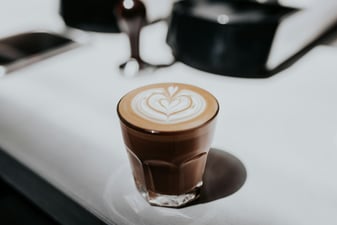 Homemade latte with espresso and milk in a clear glass cup
