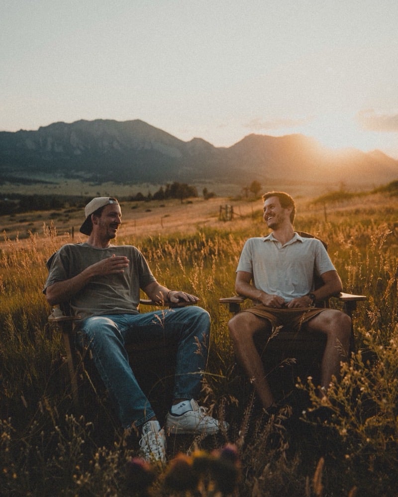Daniel Norris and Josh Caliguire, Frelio's co-founders, sitting in a field at sunset